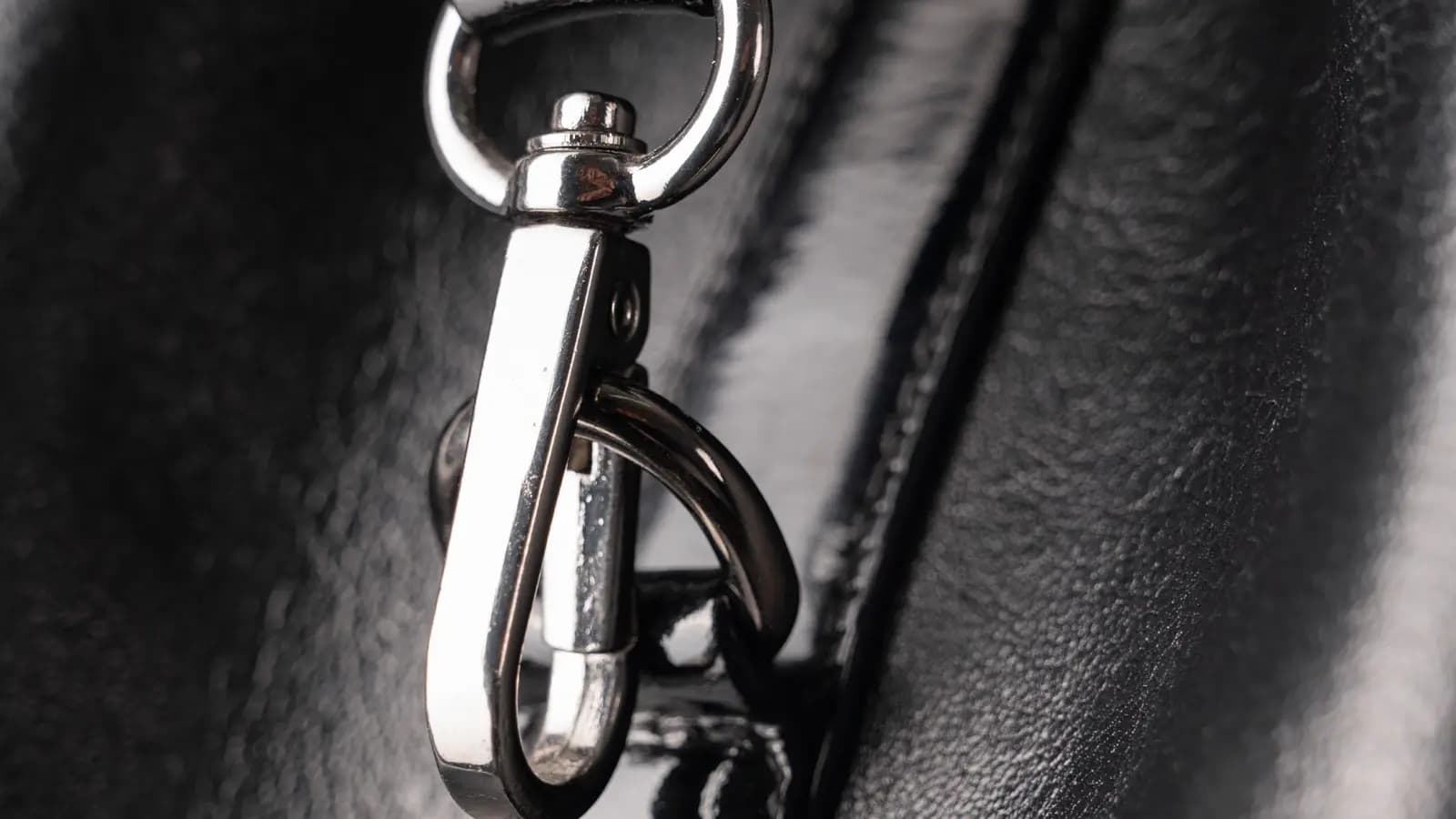 Nahaufnahme eines Metallverschlusses an einer schwarzen Ledertasche