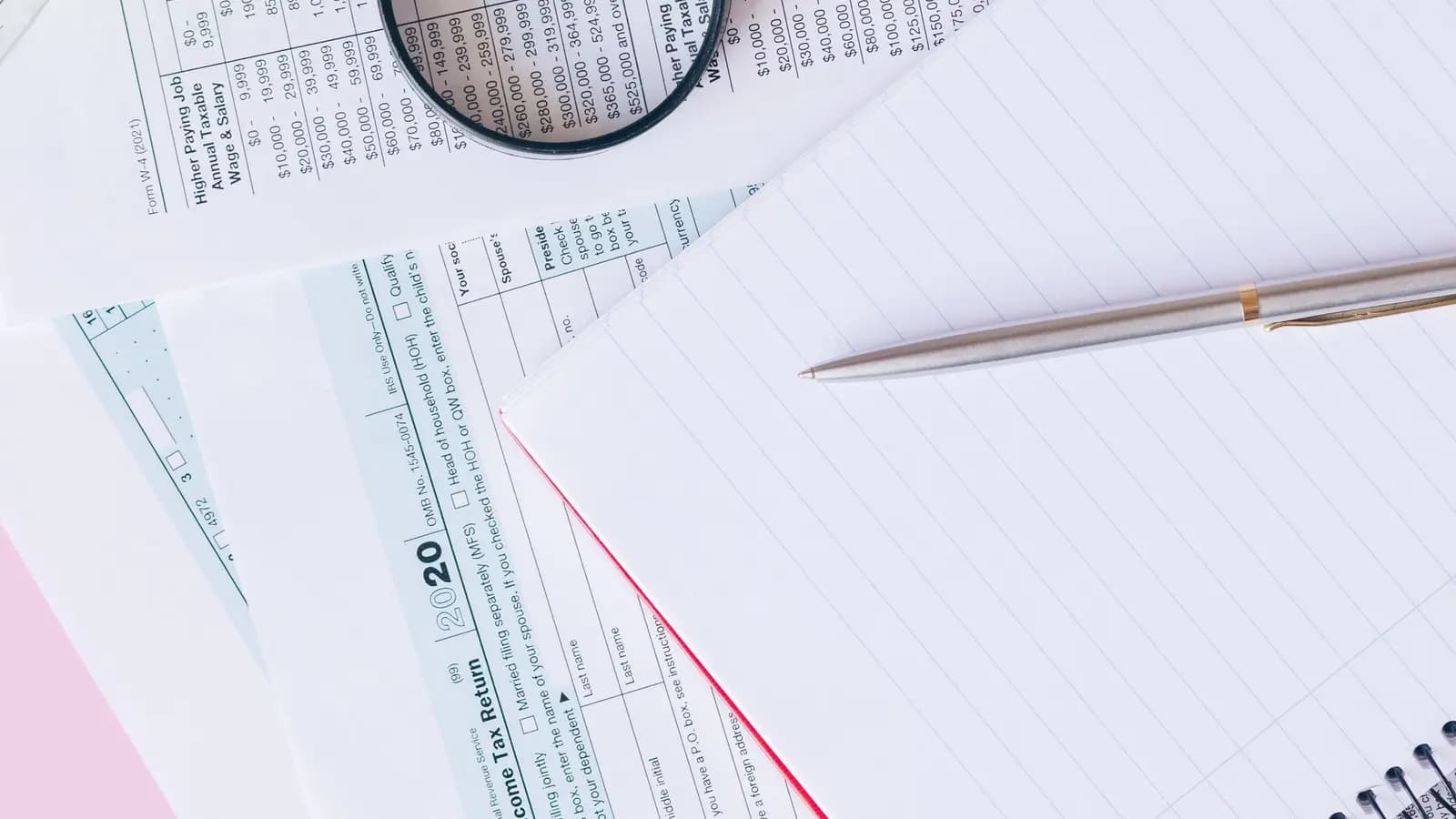 Steuerformulare, Notizblock und Stift auf einem Schreibtisch