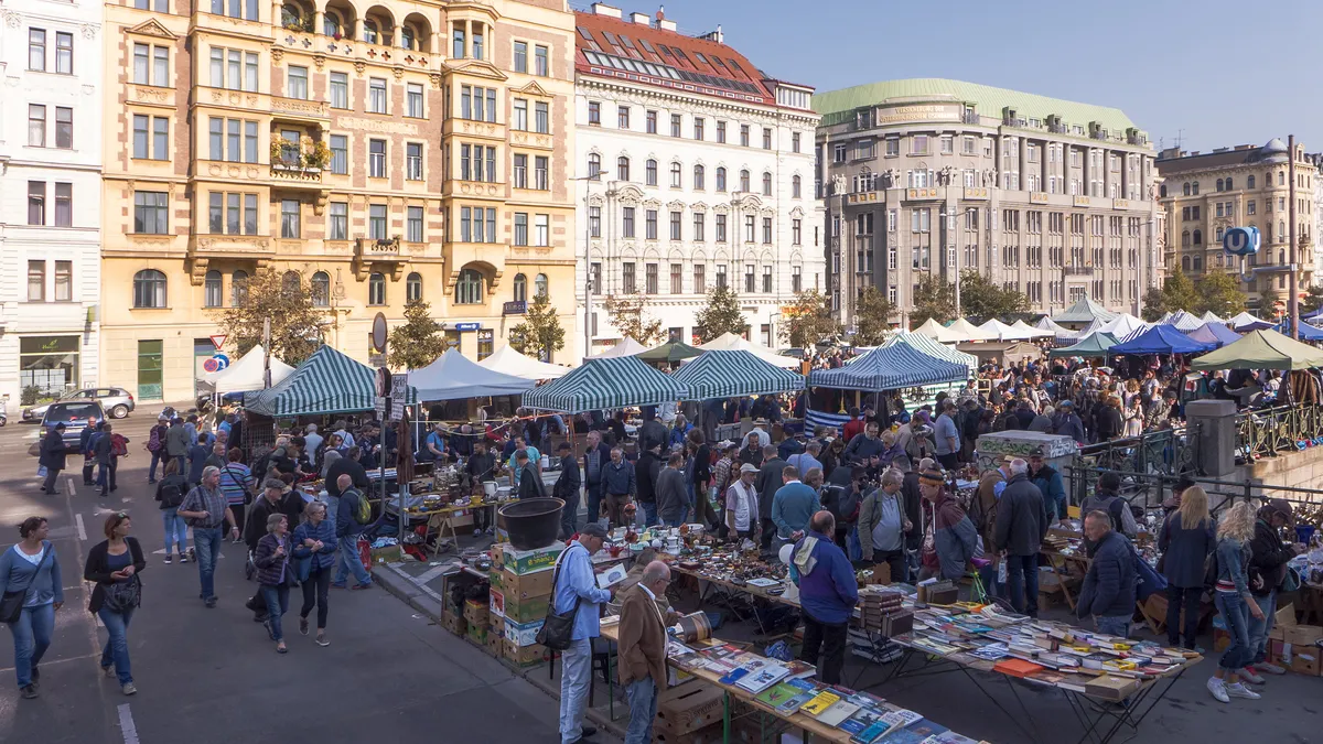 Belebter Flohmarkt mit vielen Ständen vor Altbauten