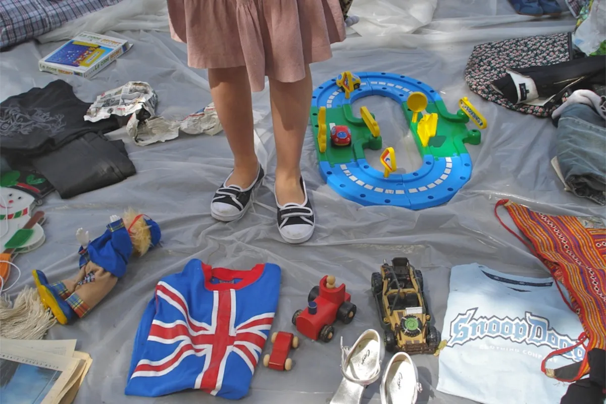 Spielzeug, Kinder-T-Shirts und eine Spielzeugeisenbahn auf einer Decke